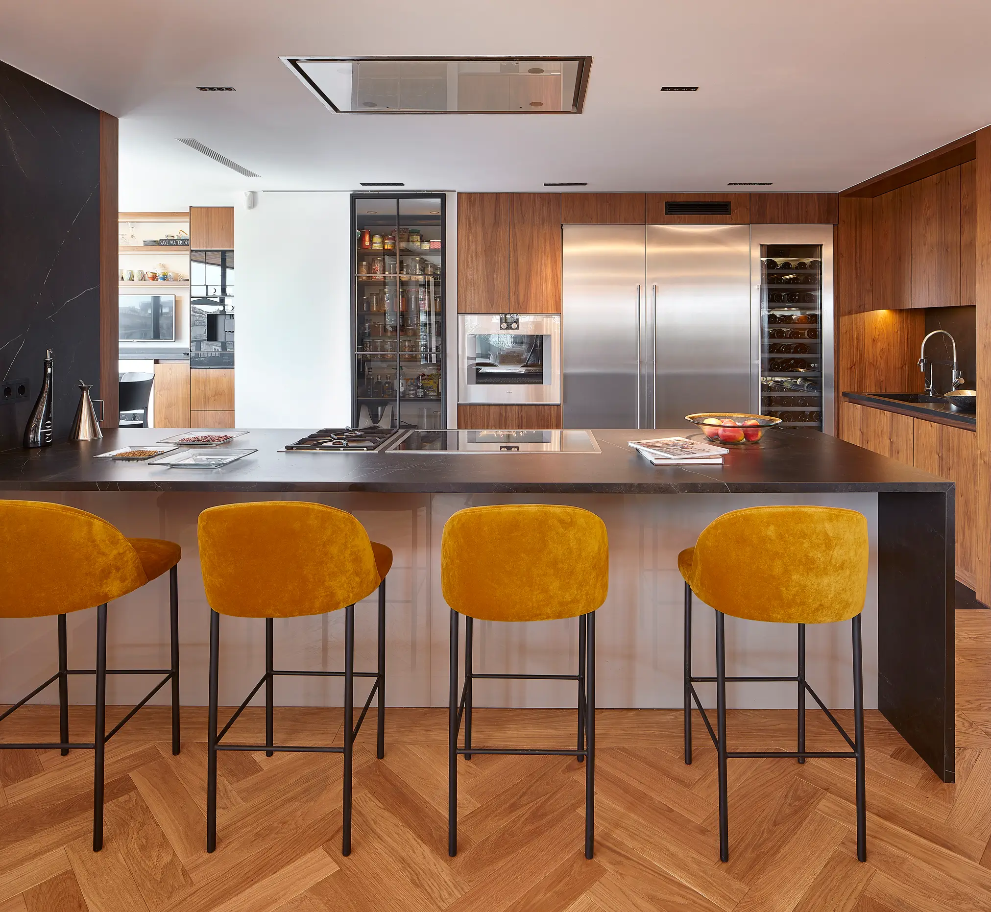 Cocina moderna con barra y taburetes.